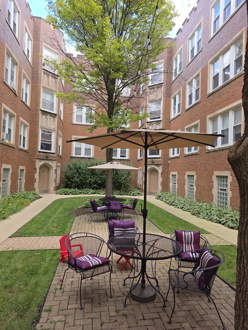 a view of a patio with a table and chairs