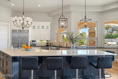 a kitchen with granite countertop a table chairs stove and cabinets
