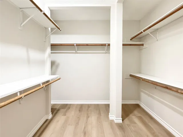 a view of walk in closet with empty racks