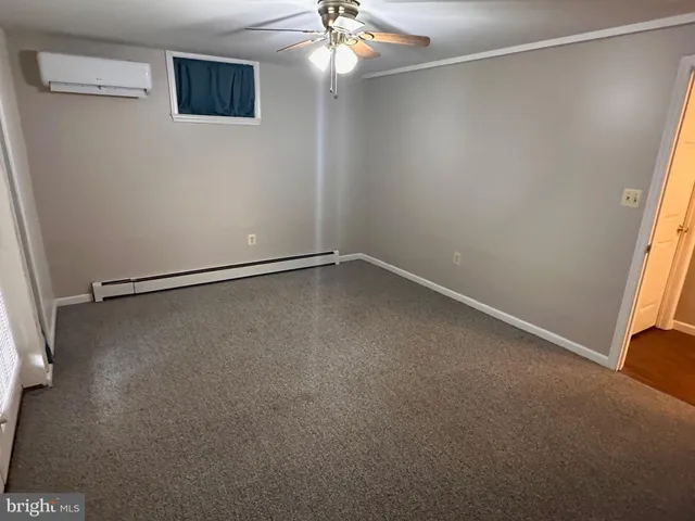 a view of a room with a empty space and a ceiling fan