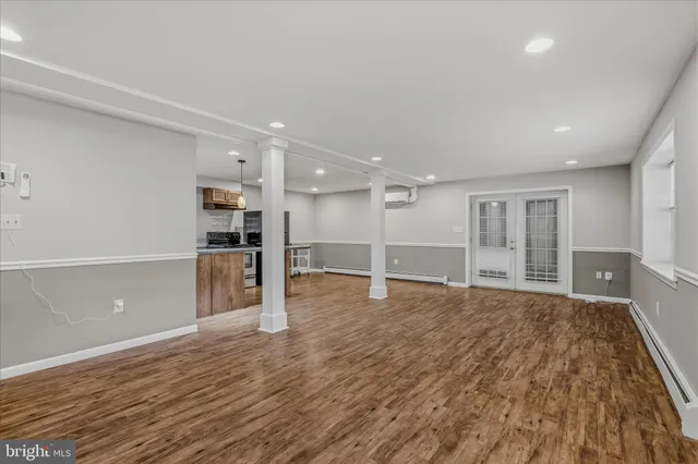 a view of empty room with wooden floor