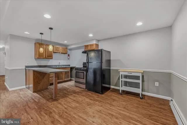 a kitchen with granite countertop a refrigerator and a stove top oven