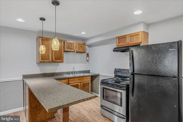 a kitchen with stainless steel appliances granite countertop a sink a stove and a refrigerator
