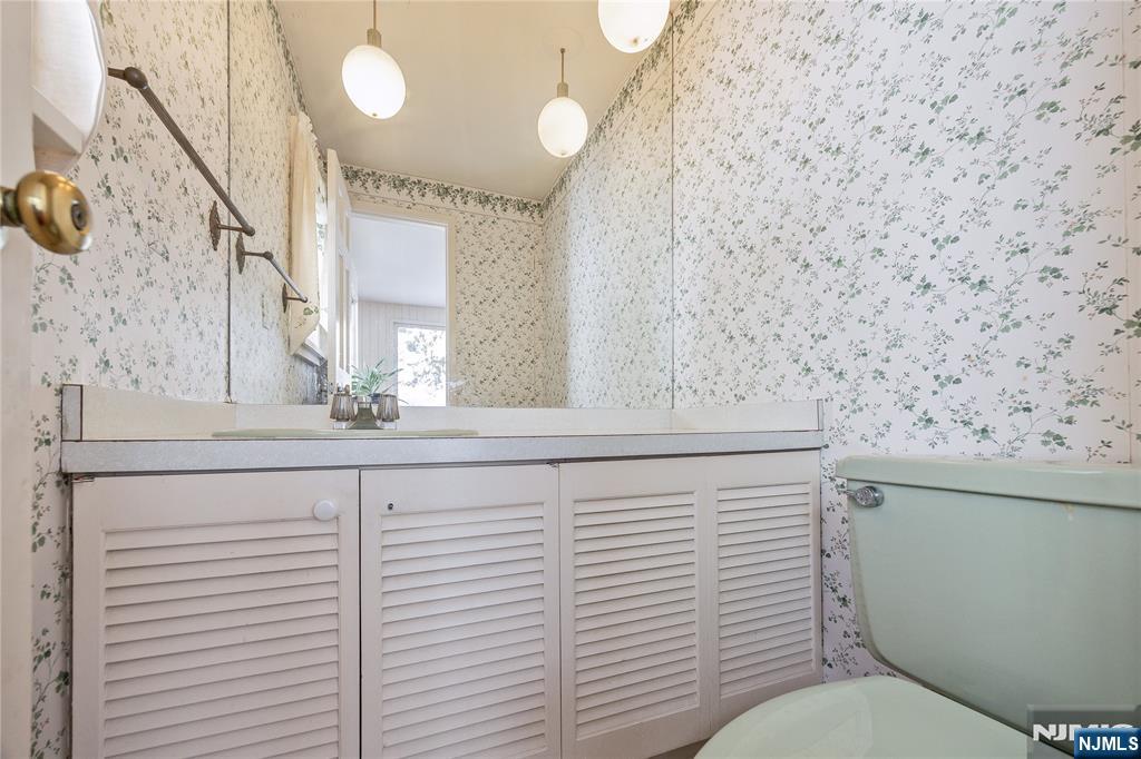 76 Forest Road Tenafly, NJ 07670 - Photo 14 of 32 a bathroom with a toilet sink and mirror
