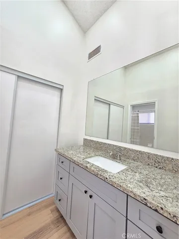 a bathroom with a granite countertop sink and a mirror