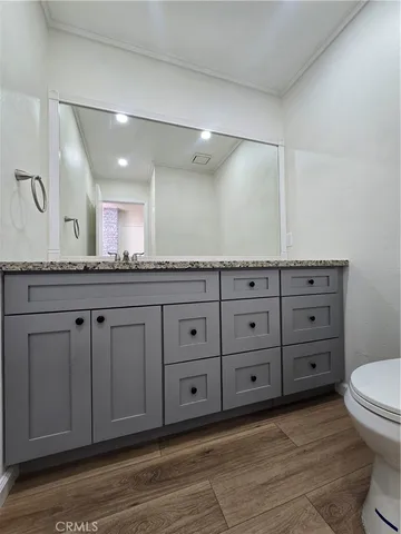 a bathroom with a granite countertop sink mirror and toilet