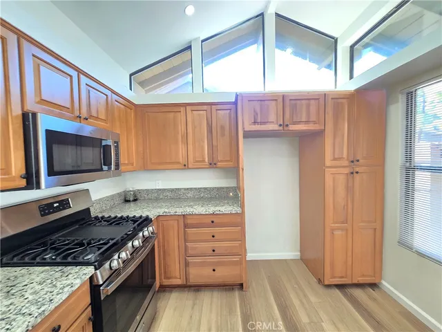 a kitchen with granite countertop a stove and a microwave