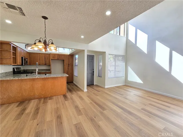 a large kitchen with stainless steel appliances granite countertop a stove and cabinets with wooden floor