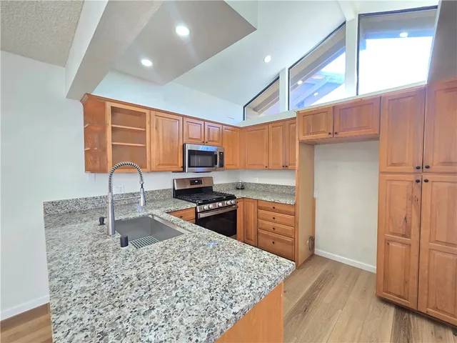a kitchen with stainless steel appliances granite countertop a refrigerator stove microwave and sink