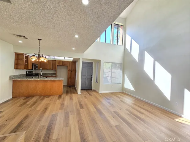 a view of kitchen with kitchen island granite countertop a sink window and a refrigerator