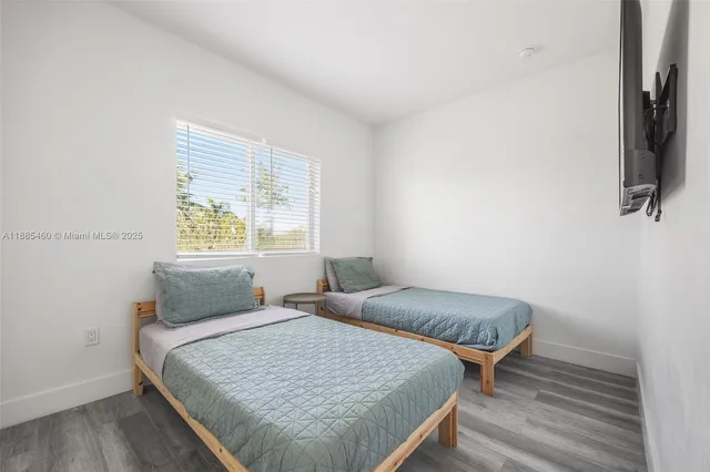 a bedroom with two beds and a flat screen tv