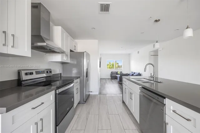 a kitchen with stainless steel appliances granite countertop a sink stove and refrigerator