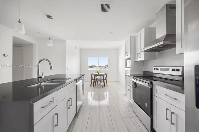 a kitchen with stainless steel appliances granite countertop a sink and cabinets