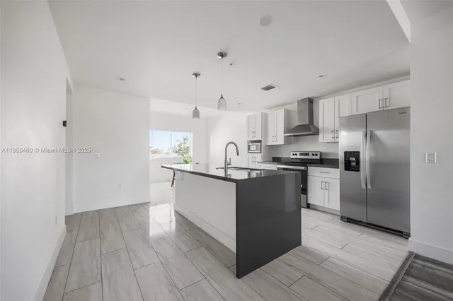 a kitchen with granite countertop a refrigerator and a stove top oven
