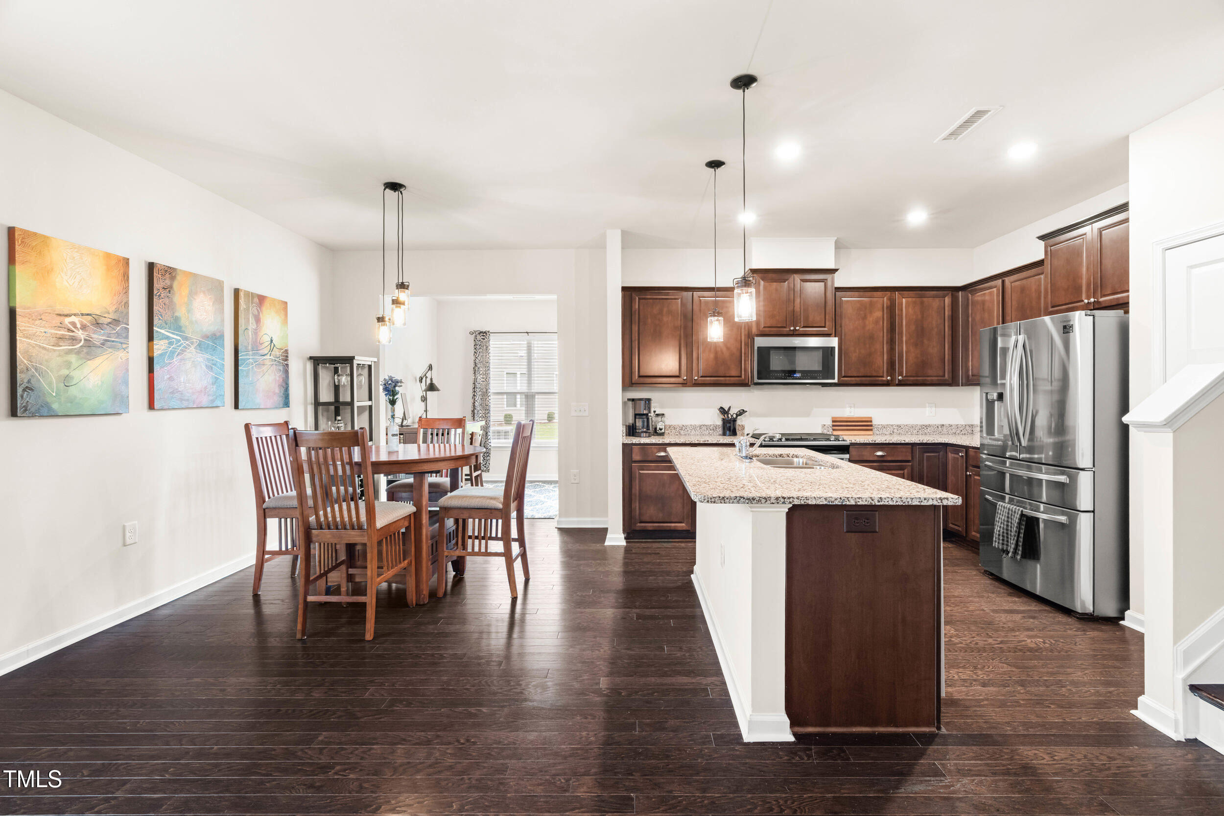 113 Lafferty Street Durham, NC 27560 - Photo 21 of 50 a kitchen with stainless steel appliances granite countertop a refrigerator a stove top oven a sink dishwasher a dining table and chairs with wooden floor