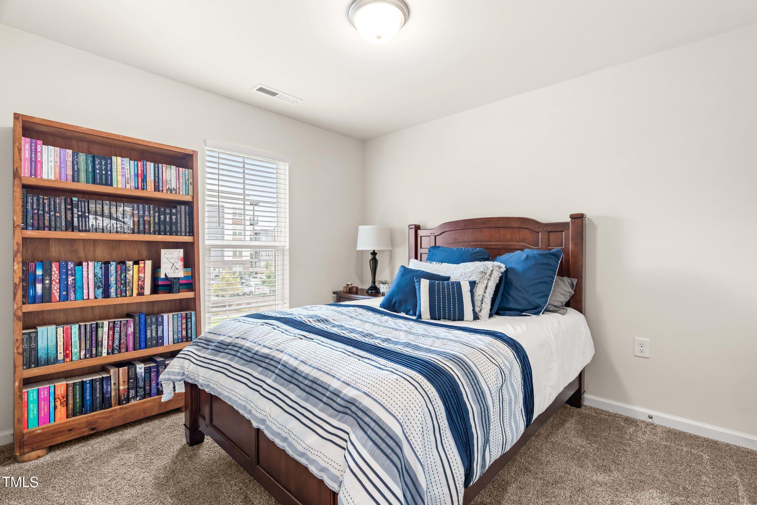 113 Lafferty Street Durham, NC 27560 - Photo 36 of 50 a bed room with a bed and a book shelf