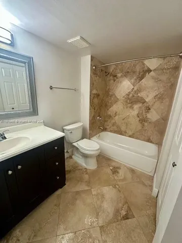 a bathroom with a sink vanity mirror and toilet