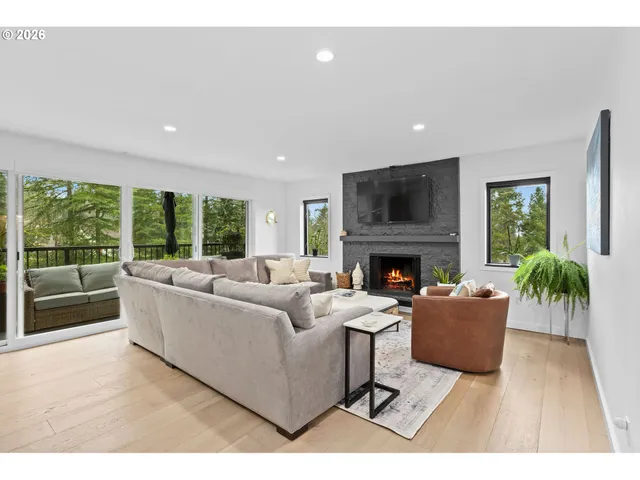 a living room with furniture a large window and a fireplace