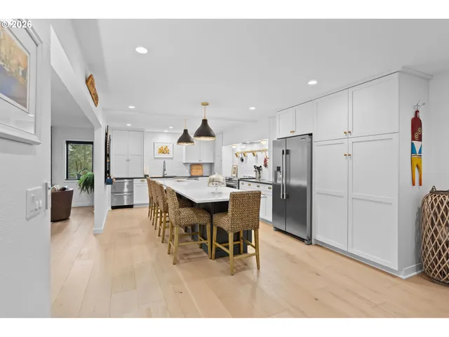 a kitchen with a dining table chairs and refrigerator
