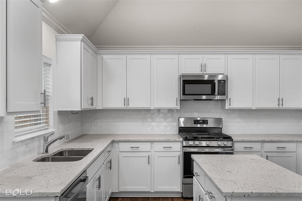 304 Prien Lk Loop Bossier City, LA 71111 - Photo 21 of 39 Kitchen featuring white shaker cabinetry, speckled countertops, stainless steel appliances, and a subway tile backsplash