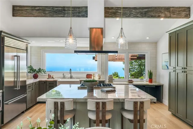 a kitchen with stainless steel appliances kitchen island granite countertop a table and chairs in it