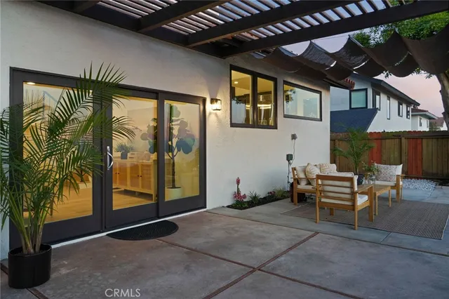 a view of a patio with couches table and chairs with potted plants and a palm tree
