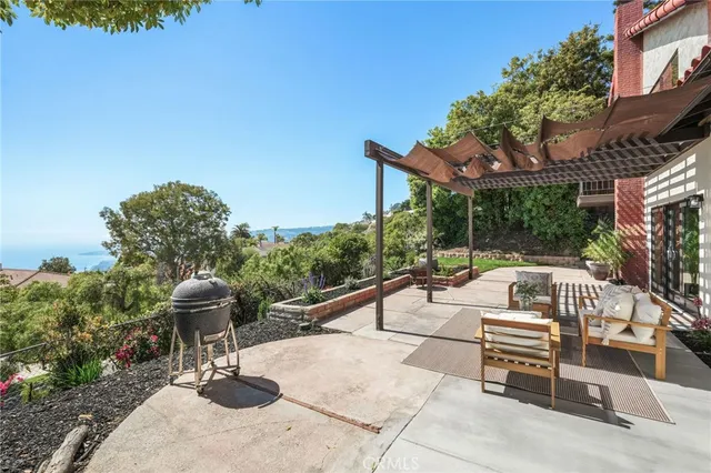 a view of a patio with couches table and chairs and potted plants