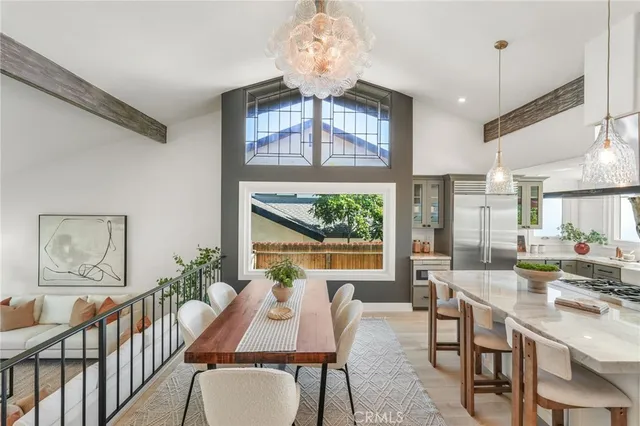 a dining room with wooden floor a chandelier a wooden table and chairs