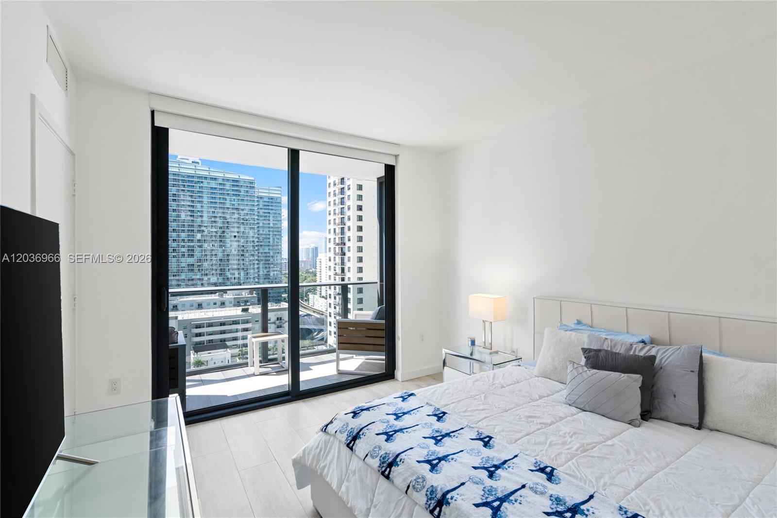 55 Southwest 9th Street, Unit 1904 Miami, FL 33130 - Photo 41 of 66 a bedroom with a large bed and a large window