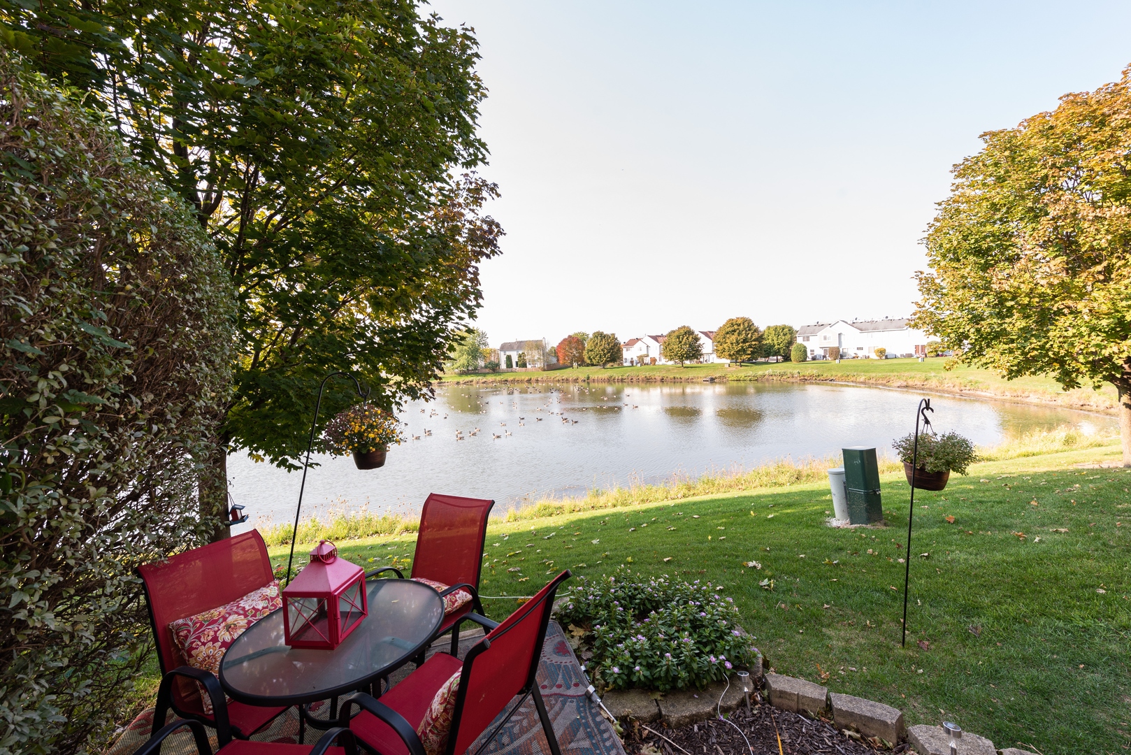10767 Cape Cod Lane Huntley, IL 60142 - Photo 14 of 14 a view of a lake with table and chairs and floor to ceiling window