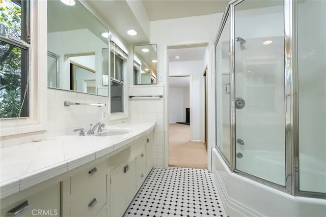 a spacious bathroom with a shower sink and mirror