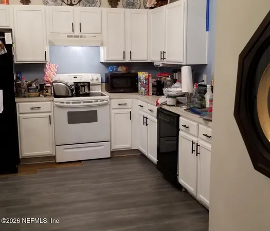 a kitchen with cabinets appliances and a wooden floor