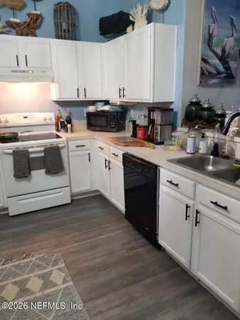 a kitchen with cabinets appliances a sink and a counter space