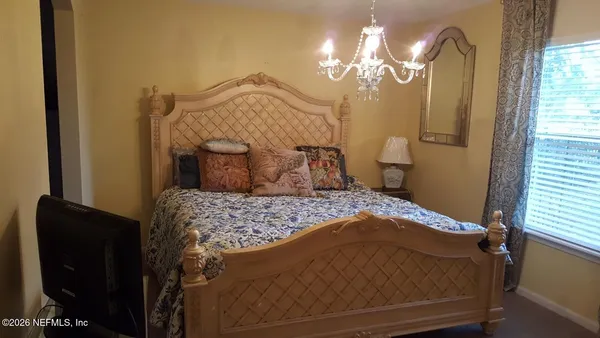 a bedroom with a bed and a chandelier