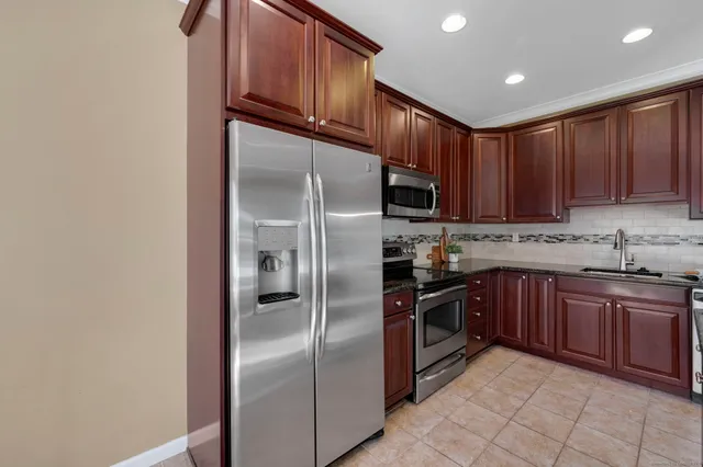 a kitchen with stainless steel appliances granite countertop a refrigerator stove a sink and dishwasher