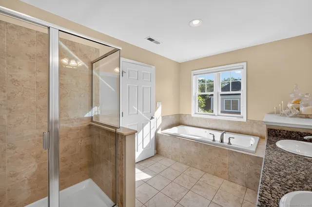 a spacious bathroom with a tub a sink and a large window