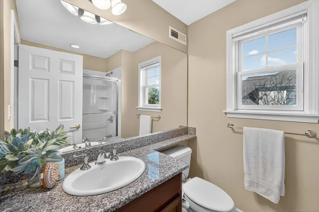 a bathroom with a sink vanity mirror and toilet