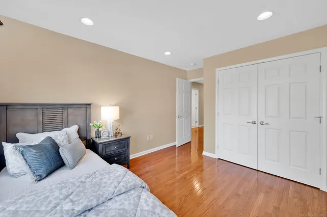 a bedroom with a large bed and a wooden floor