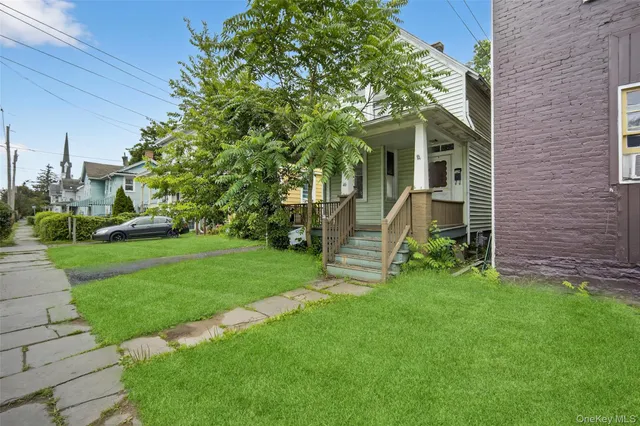 a view of a house with a yard and sitting area