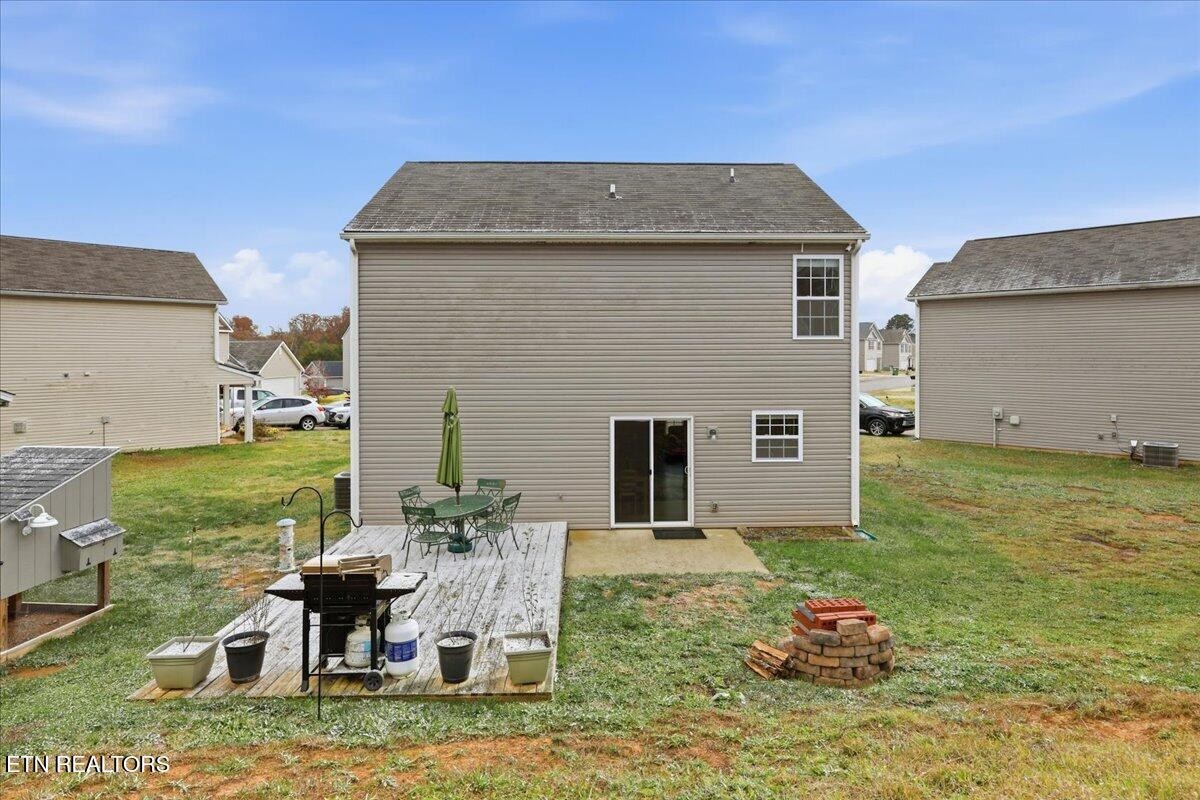 7151 Forest Willow Lane Corryton, TN 37721 - Photo 24 of 24 a backyard of a house with table and chairs
