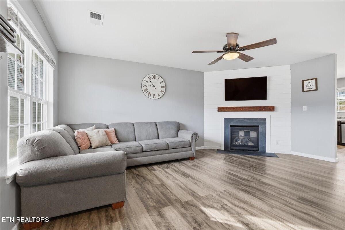 7151 Forest Willow Lane Corryton, TN 37721 - Photo 4 of 24 a living room with furniture a fireplace and a flat screen tv