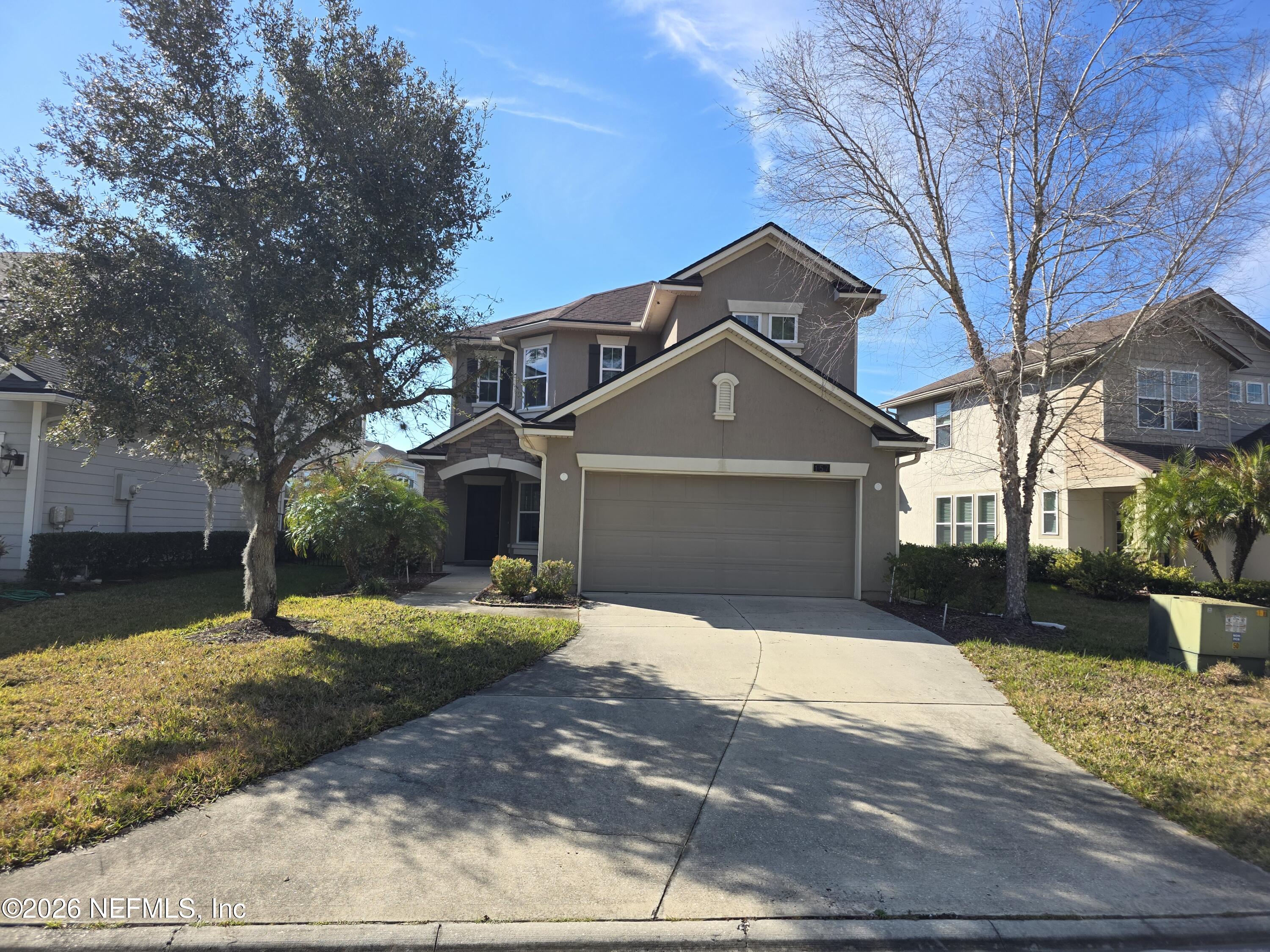 a front view of a house with a yard and garage