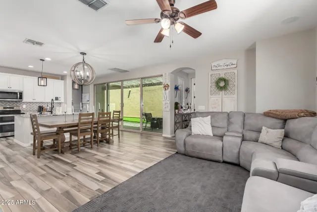 a living room with furniture a clock and a chandelier