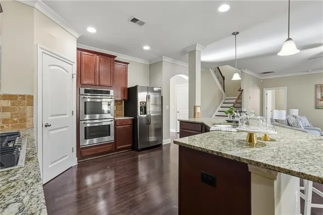 a kitchen with stainless steel appliances granite countertop a refrigerator a sink and a stove