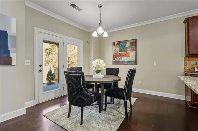 a dining room with furniture a chandelier and wooden floor