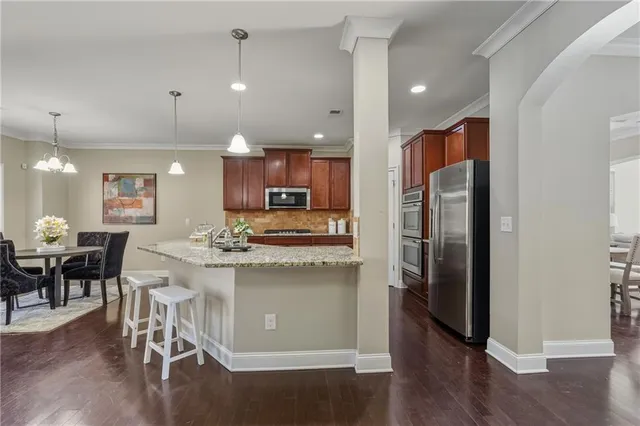 a kitchen with kitchen island a refrigerator and a dining table