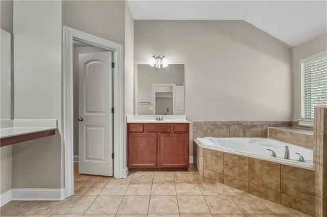 a bathroom with a bathtub sink and mirror