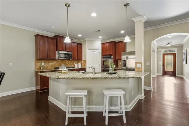 a kitchen with kitchen island granite countertop a center island a sink stainless steel appliances and cabinets