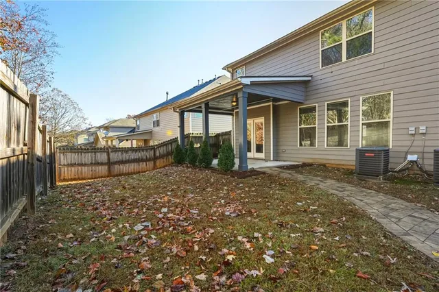 a view of a house with a small yard and wooden fence
