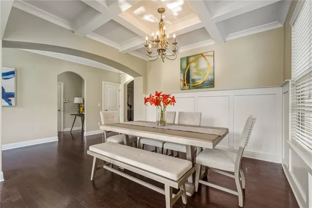 a dining room with furniture a chandelier and wooden floor